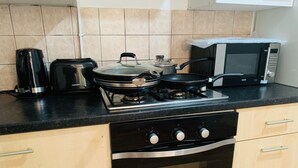 Una cocina equipada con estufa, tostadora, microondas y cafetera.