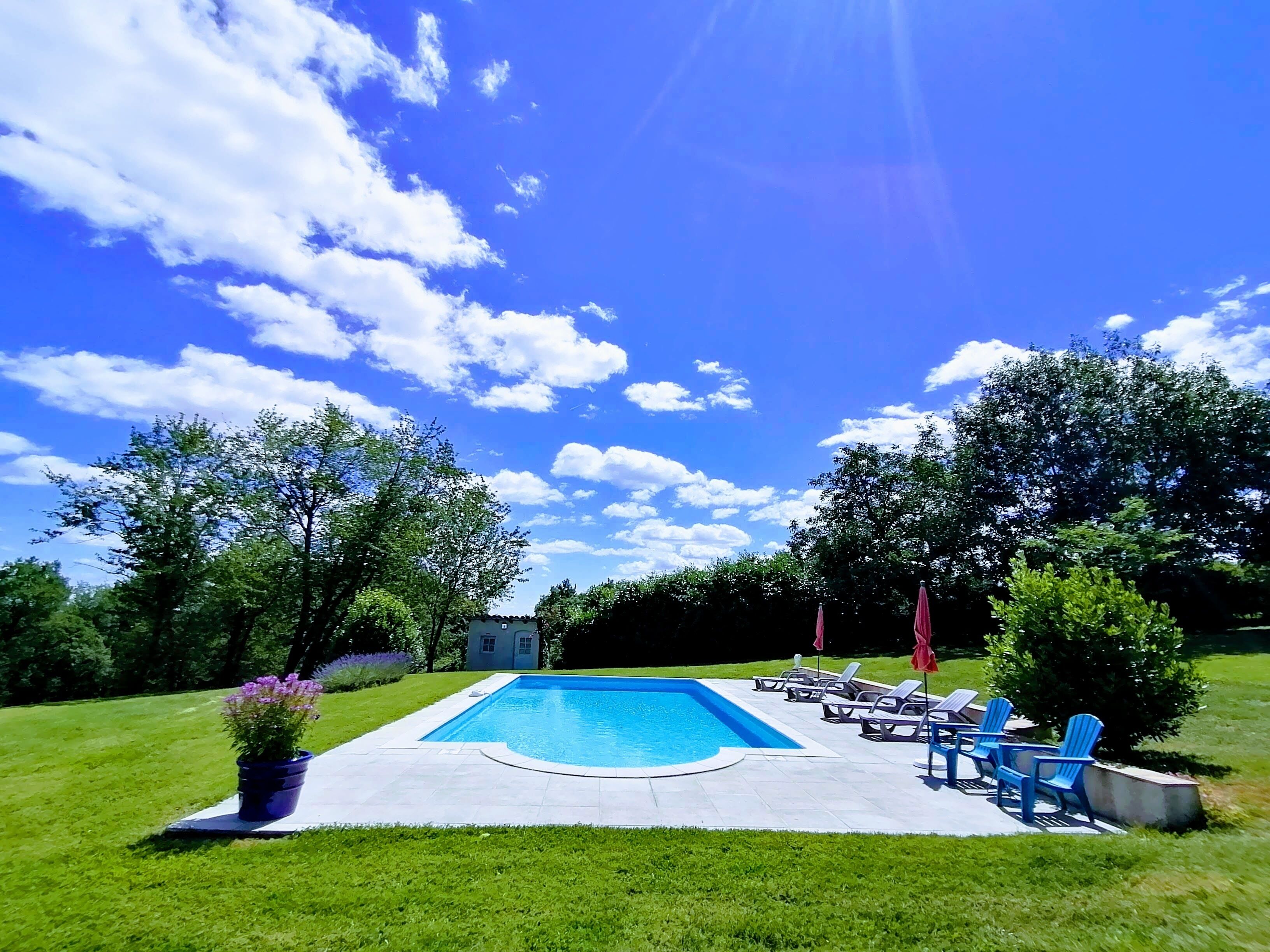 Una piscina al aire libre de temporada, sombrillas, tumbonas