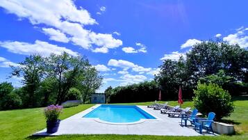 Una piscina al aire libre de temporada, sombrillas, tumbonas
