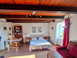 Un dormitorio acogedor con cama, mesitas de noche, un escritorio y una estantería.
