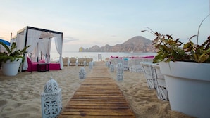 A beach wedding setup with a wooden walkway, white canopies, and seating areas. - PARTY on Cabo Villas & Mango Deck Executive Suite (El Medano)
