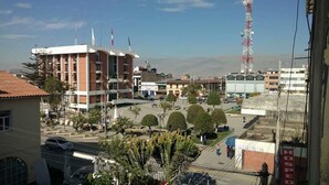 Un hotel con un edificio grande, un estacionamiento y una torre de comunicaciones alta al fondo.