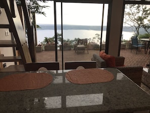 Enjoy breathtaking views of the lake from this stylish room, featuring a large window and comfortable outdoor seating area.