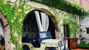 A beige off-road vehicle parked under a stone archway with ivy. - Cortijo Cal Rajoler (Cabanes)