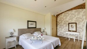 A bedroom with two beds, a white dresser, a nightstand, and a framed picture on the wall. - Cortijo Cal Rajoler (Cabanes)
