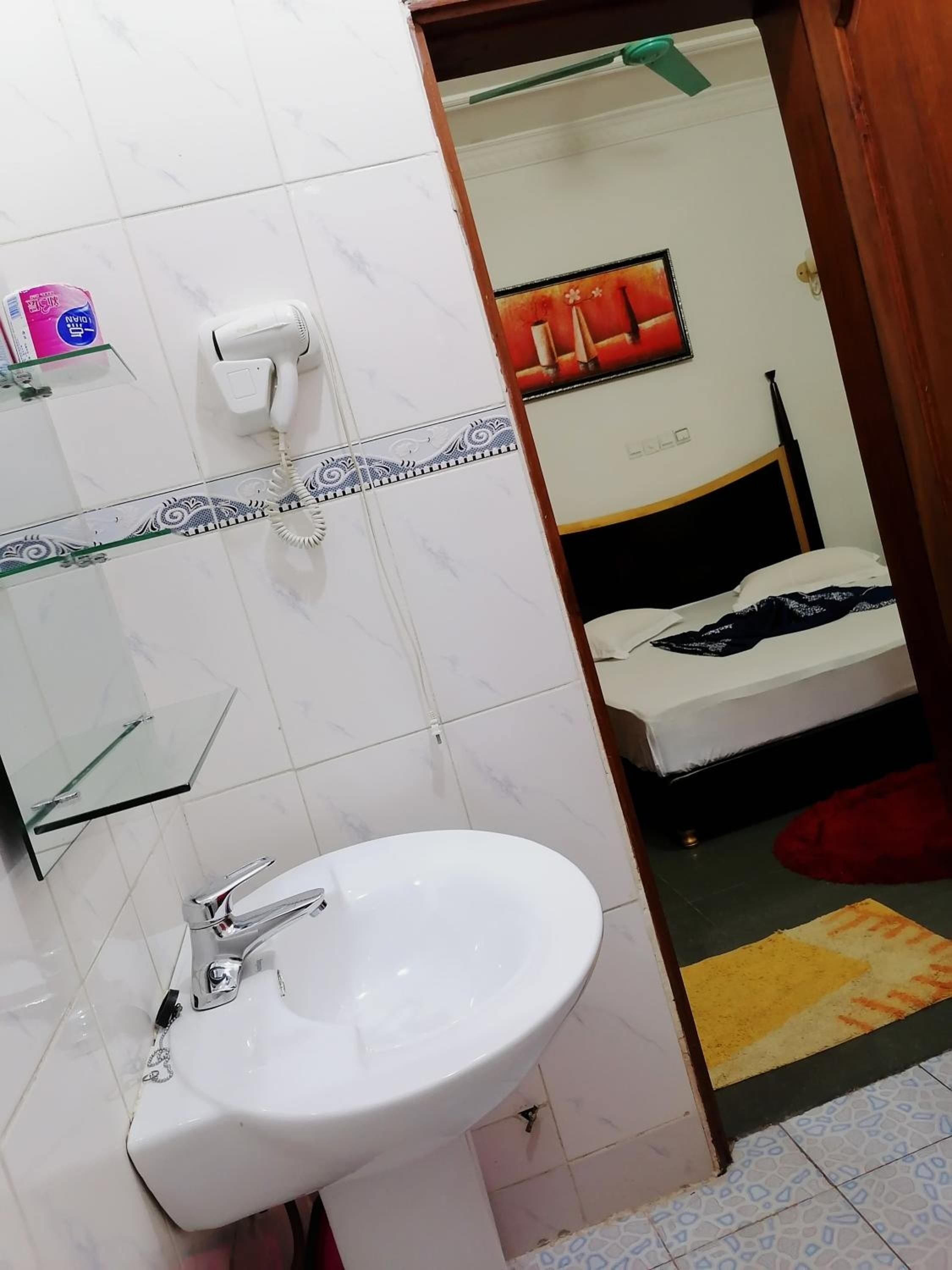 A bathroom with a white sink, a telephone, and a mirror.