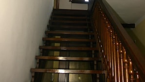 A wooden staircase with a dark handrail and a white wall. - Ai Cappuccini (Racconigi)