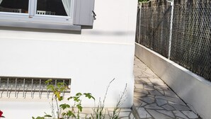 Un bâtiment blanc avec une fenêtre et une clôture en treillis métallique.