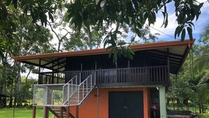 A two-story building with a balcony, a staircase, and a covered outdoor area. - Finca el Refugio de Papito (El Molino)