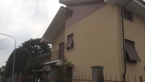 A two-story building with a balcony, a metal fence, and a no parking sign. - Casa Salice (Racconigi)