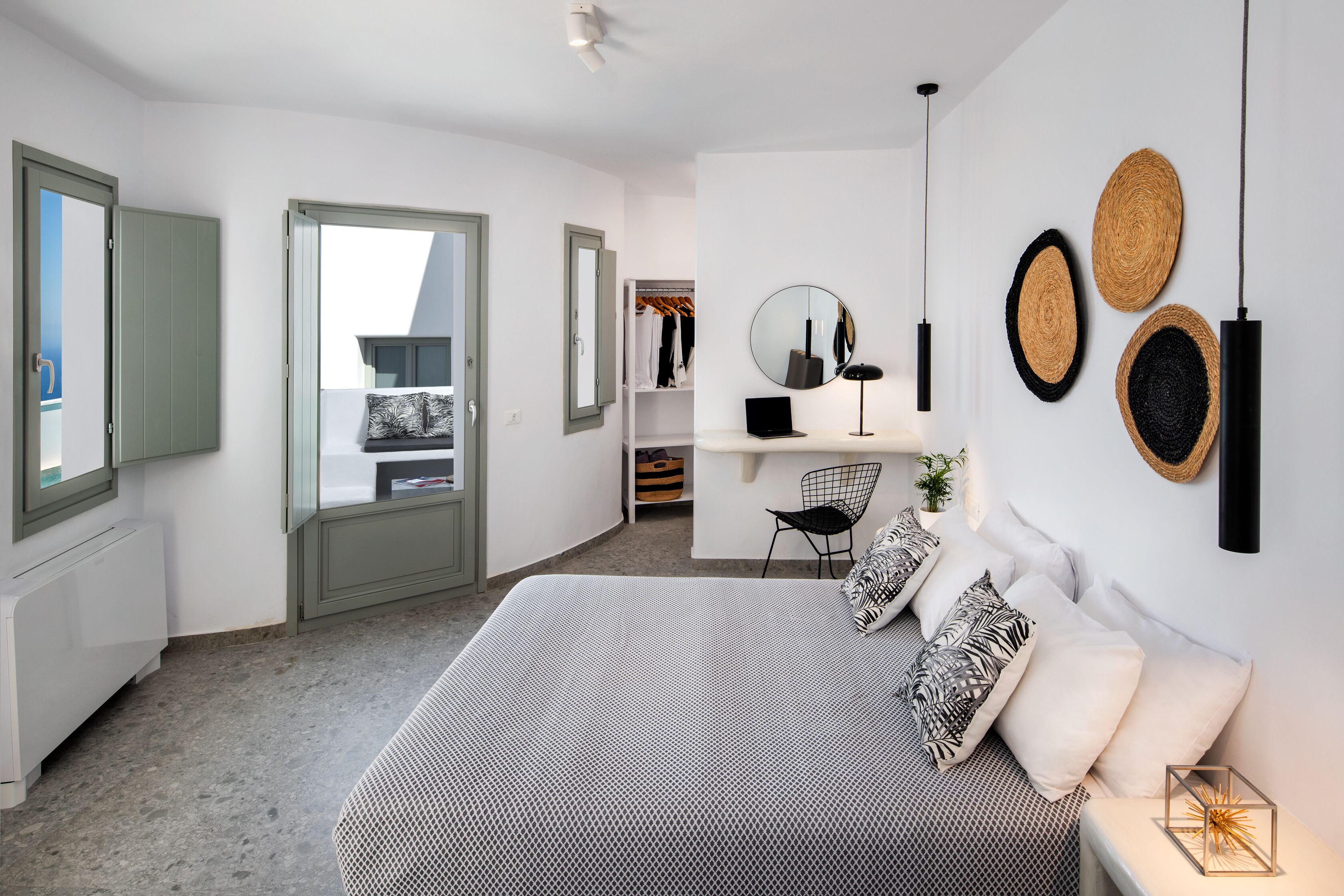 A modern bedroom with a large bed, a desk, and a wardrobe.