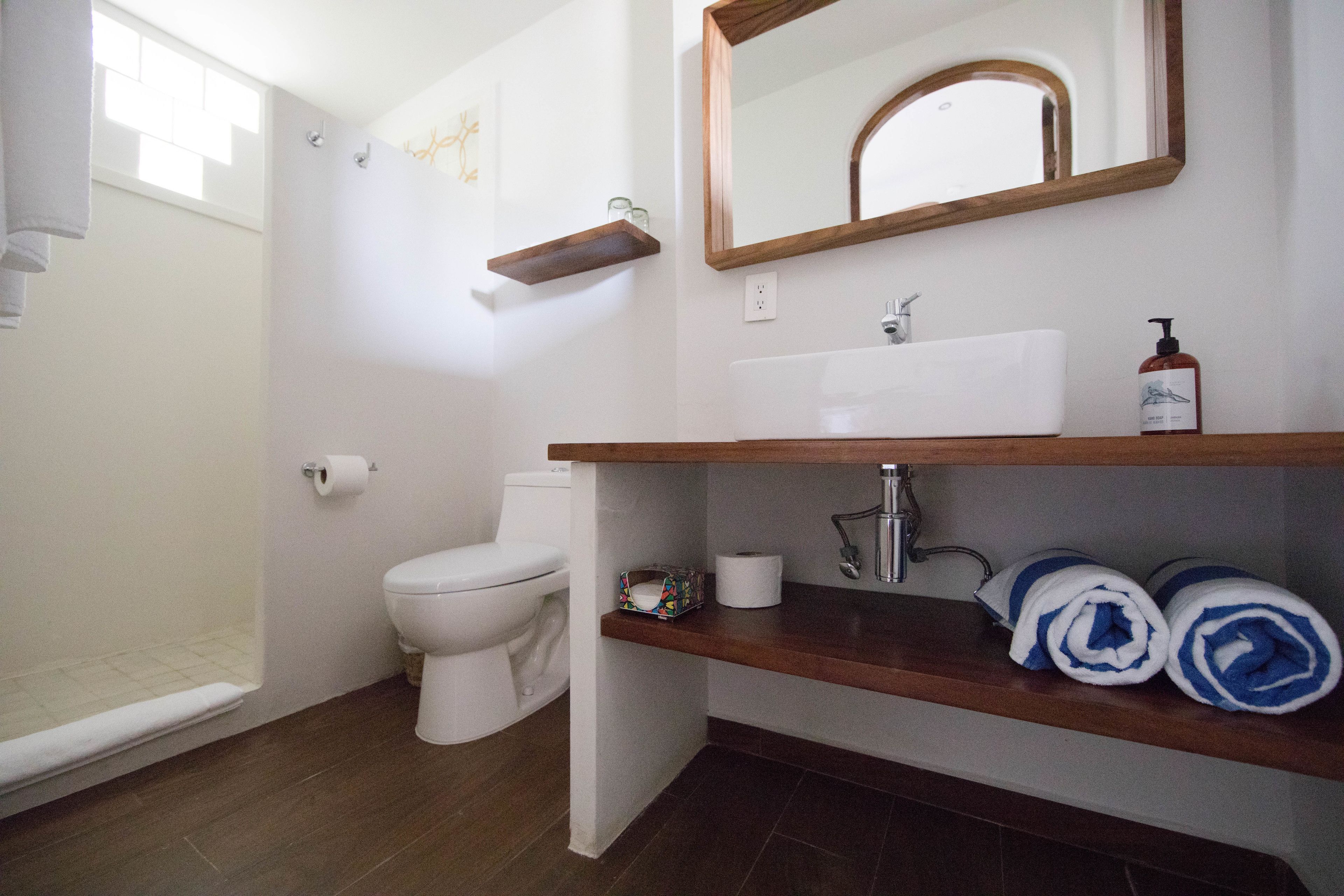 Une salle de bain équipée de toilettes, d’une douche, d’un lavabo et d’un porte-serviettes.