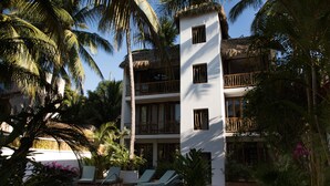 Ein Resort mit Pool, Liegestühlen und einem Gebäude mit Balkonen.