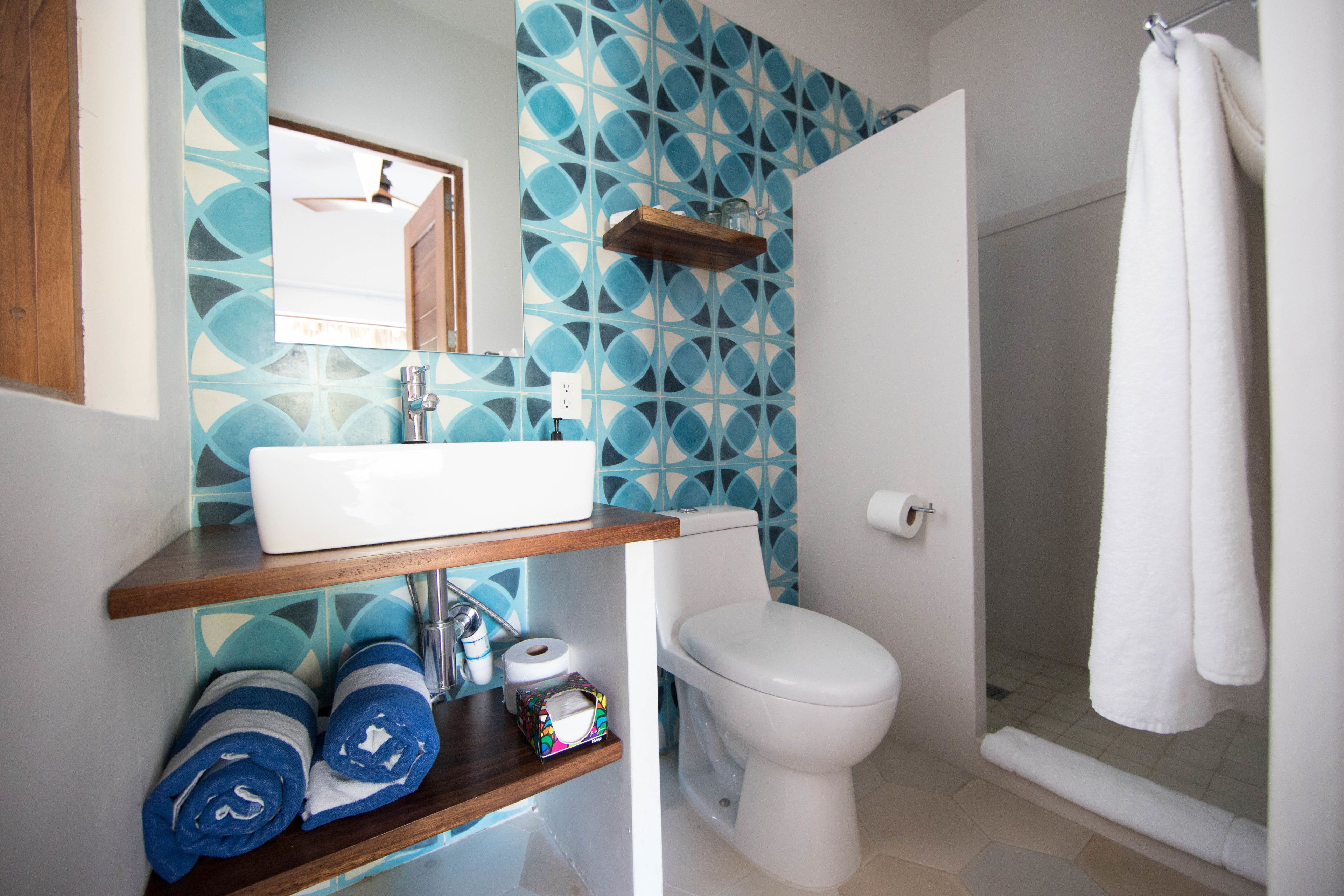 A bathroom with a white sink, toilet, and shower area.