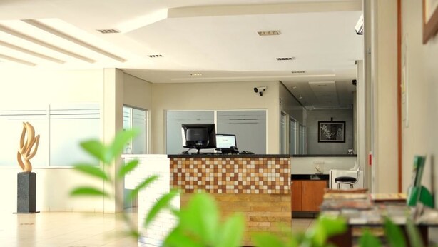 A modern kitchen with a tiled backsplash, a built-in stove, and a countertop. - Hotel Executivo (Araguaina)