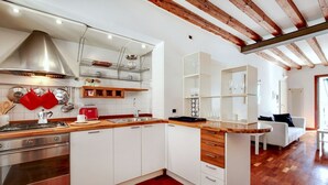 Een moderne keuken met witte kastjes, een houten aanrecht en een roestvrijstalen afzuigkap.