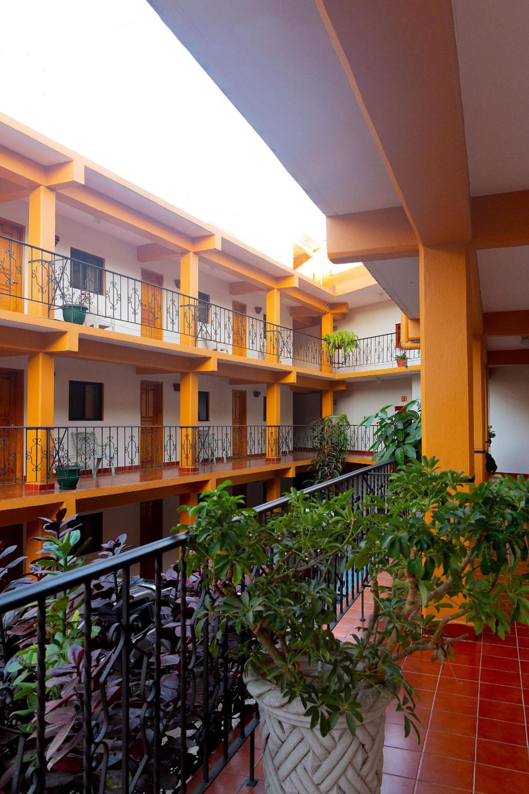 A multi-level atrium with balconies, railings, and potted plants.