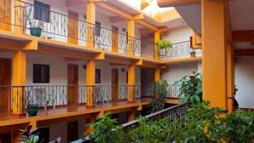 A multi-level atrium with balconies, railings, and potted plants.