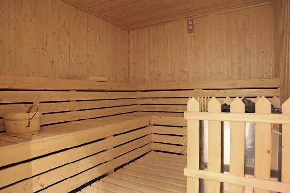 Un sauna avec des bancs en bois et une cloison en bois.
