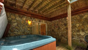 A stone-walled bathroom with a wooden ceiling and a hot tub. - North Georgia Cabin, Sleeps 8, Pet Friendly (Morganton)
