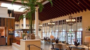 A spacious lobby with a high ceiling, large windows, and a central seating area. - Beautiful, First Floor South Villa at King & Prince with Resort Amenities (St Simons Island)