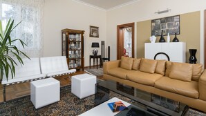 A living room with a white sofa, a beige sofa, a glass coffee table, and a patterned rug. - Villa Diocletian (Split)