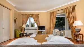 A hotel room with two beds, a TV, a sofa, a chair, a small table, and a lamp. - Villa Diocletian (Split)
