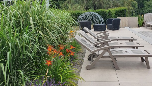 An outdoor patio with lounge chairs and a decorative umbrella.