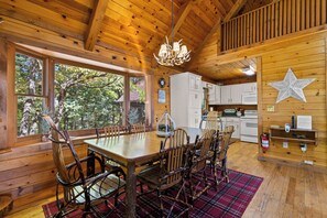 A wooden interior with a dining table, chairs, a kitchen area, and large windows. - Top of Mountain Views, Pet Friendly, Fenced Yard (Morganton)