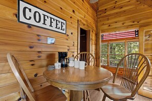 A wooden interior with a round table, chairs, a coffee station, and a sign that reads 'COFFEE'. - Top of Mountain Views, Pet Friendly, Fenced Yard (Morganton)