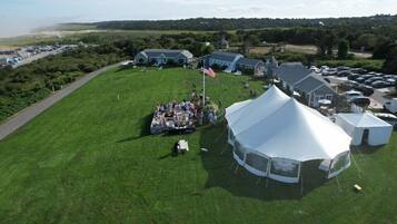 An aerial view of a campsite with tents, a flag, and a grassy field.