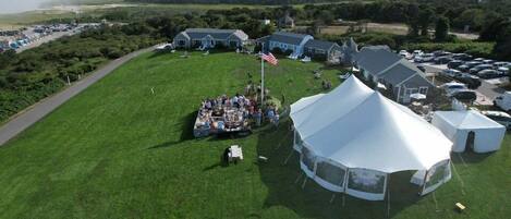 An aerial view of a campsite with tents, a flag, and a grassy field.