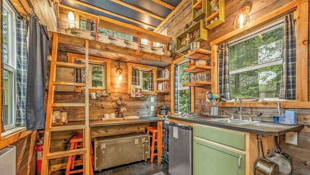 A compact kitchen with wooden walls, a sink, and a refrigerator. - Fun Lofted Waterfront Home w/ Sauna and BBQ (Longview)