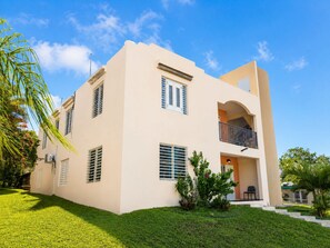 A two-story building with a balcony, a flat roof, and a well-maintained lawn. - Colinas del Atlantico for 18 People (Isabela)