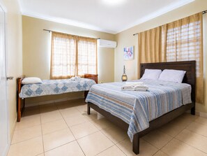 A hotel room with two beds, a ceiling fan, and a wall-mounted air conditioner. - Colinas del Atlantico for 18 People (Isabela)