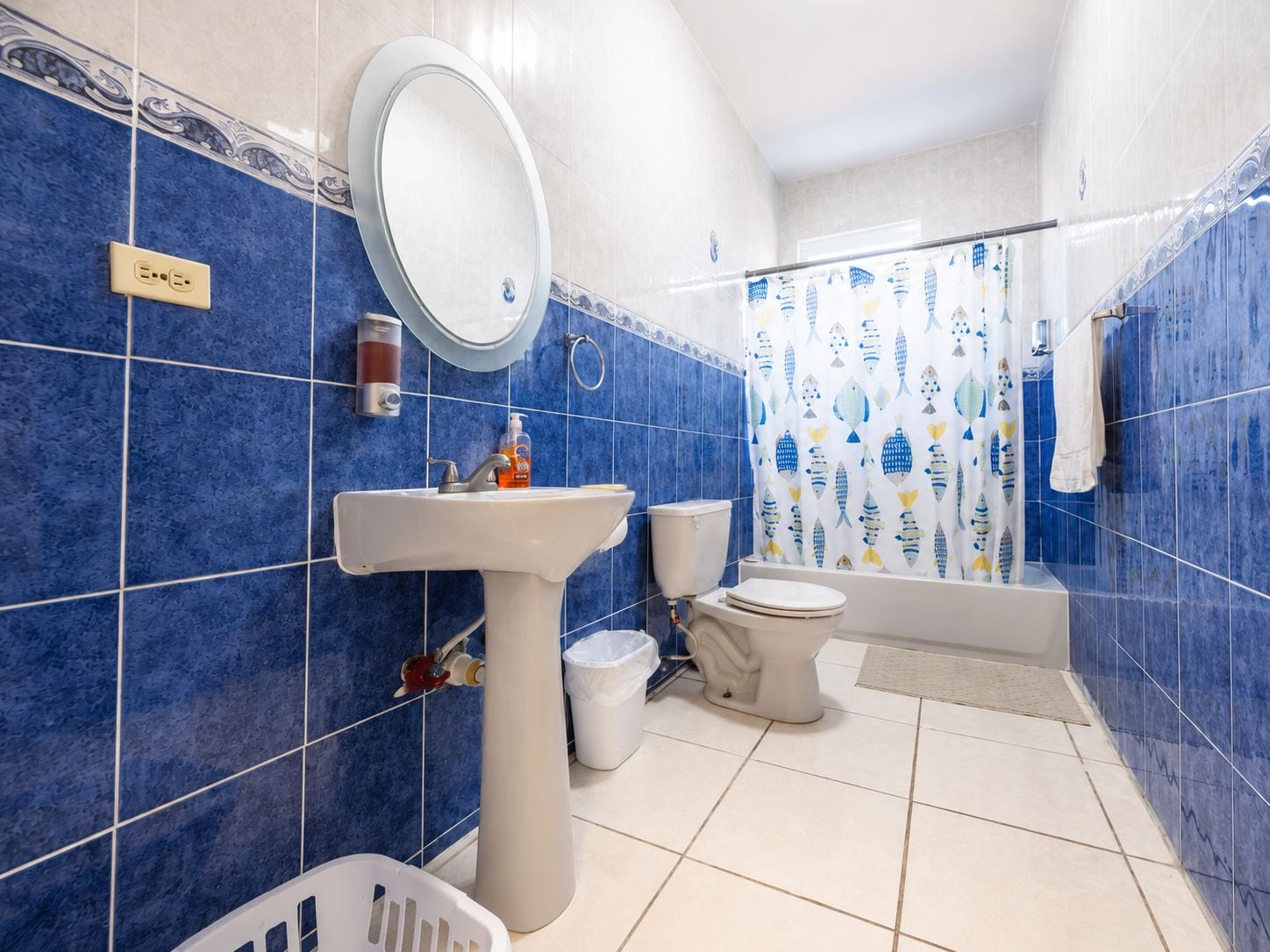 Baño con lavamanos, inodoro y cortina de ducha.