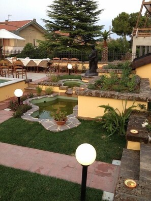 A garden with a pond, outdoor seating, and a statue. - Villa Letizia (Pescara)