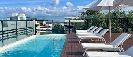 Piscine extérieure, parasols de plage, chaises longues