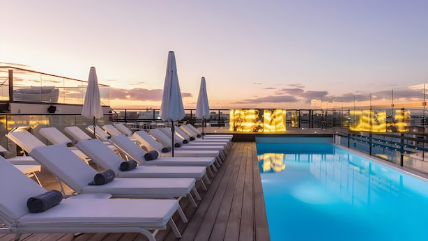 A rooftop pool area with sun loungers and umbrellas, surrounded by a wooden deck. - Serenity Hotel Boutique by Alsol (Playa del Carmen)