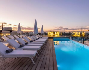 A rooftop pool area with sun loungers and umbrellas, surrounded by a wooden deck. - Serenity Hotel Boutique by Alsol (Playa del Carmen)