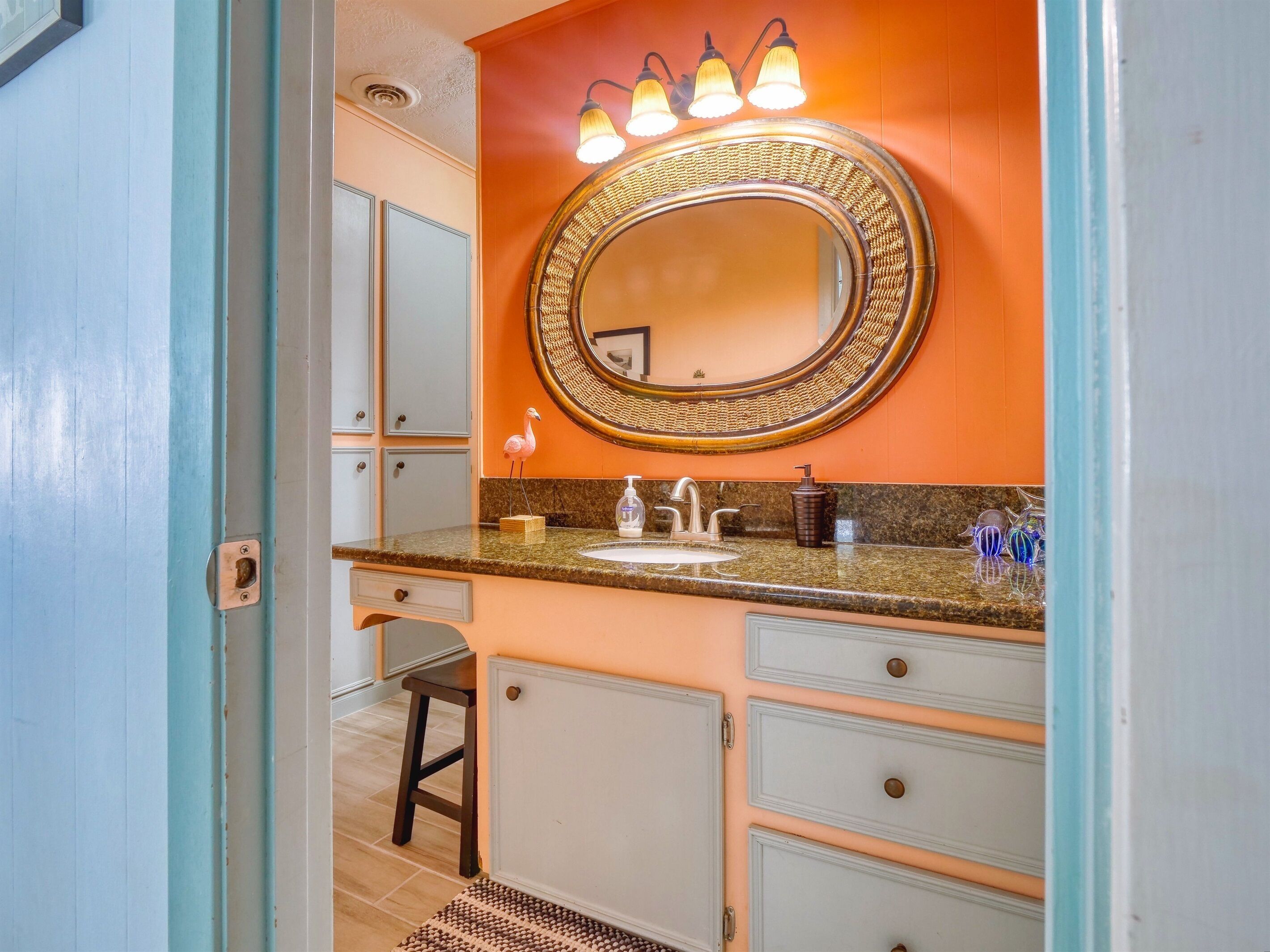 A bathroom with a vanity, sink, and mirror.