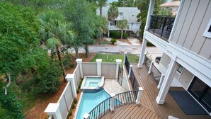 Propiedad residencial con terraza de madera, piscina y patio trasero cercado.