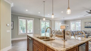 Una cocina amplia con una isla grande, armarios de madera y un comedor con sofá y sillas.