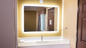 Ein Badezimmer mit Waschbecken, Spiegel und Tür.