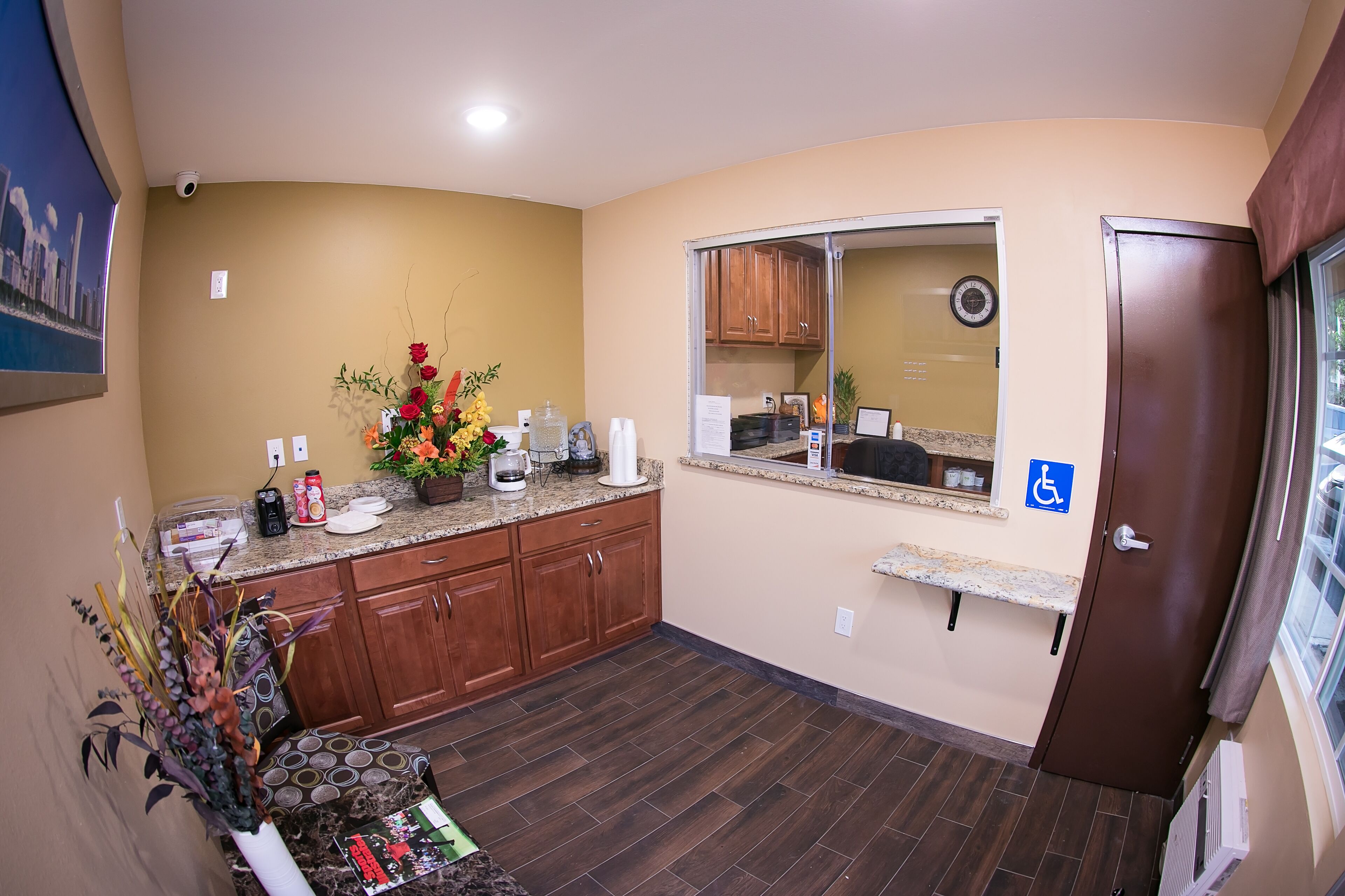 A kitchen with wooden cabinets, a countertop with various items, a window, and a door.
