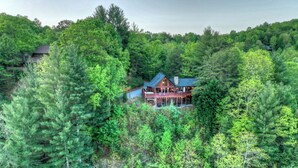 A large, two-story log cabin surrounded by dense forest. - Mountain View, Hot Tub, Large Deck, Fire Pit Area (Morganton)