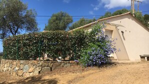 A stone wall with a garden and a building with a sloped roof. - Charming Small Villa Any Comfort Ideal 4 People 2bedroom close Tizzano (Sartène)