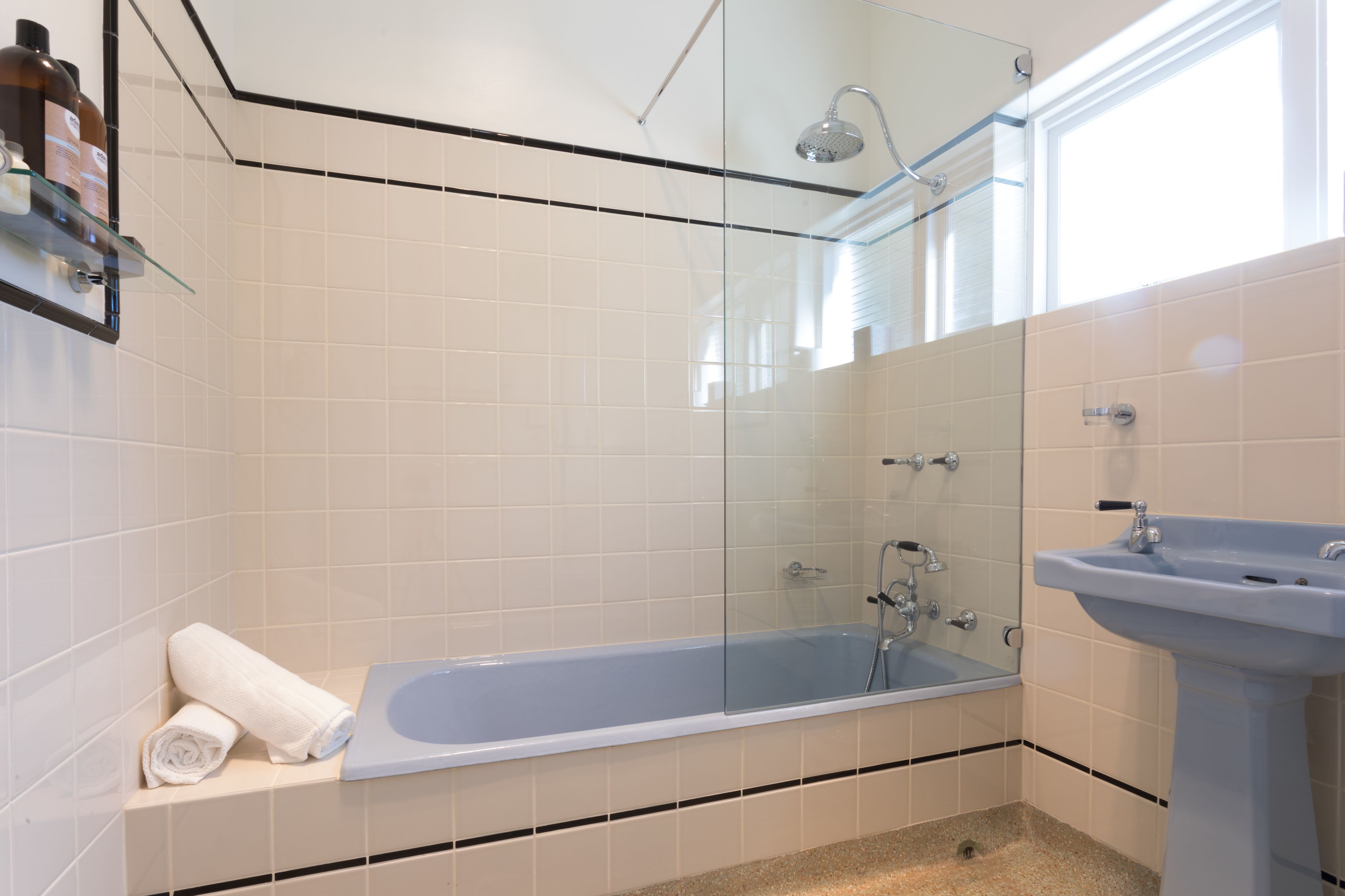 A bathroom with a glass-enclosed shower, a bathtub, and a sink.