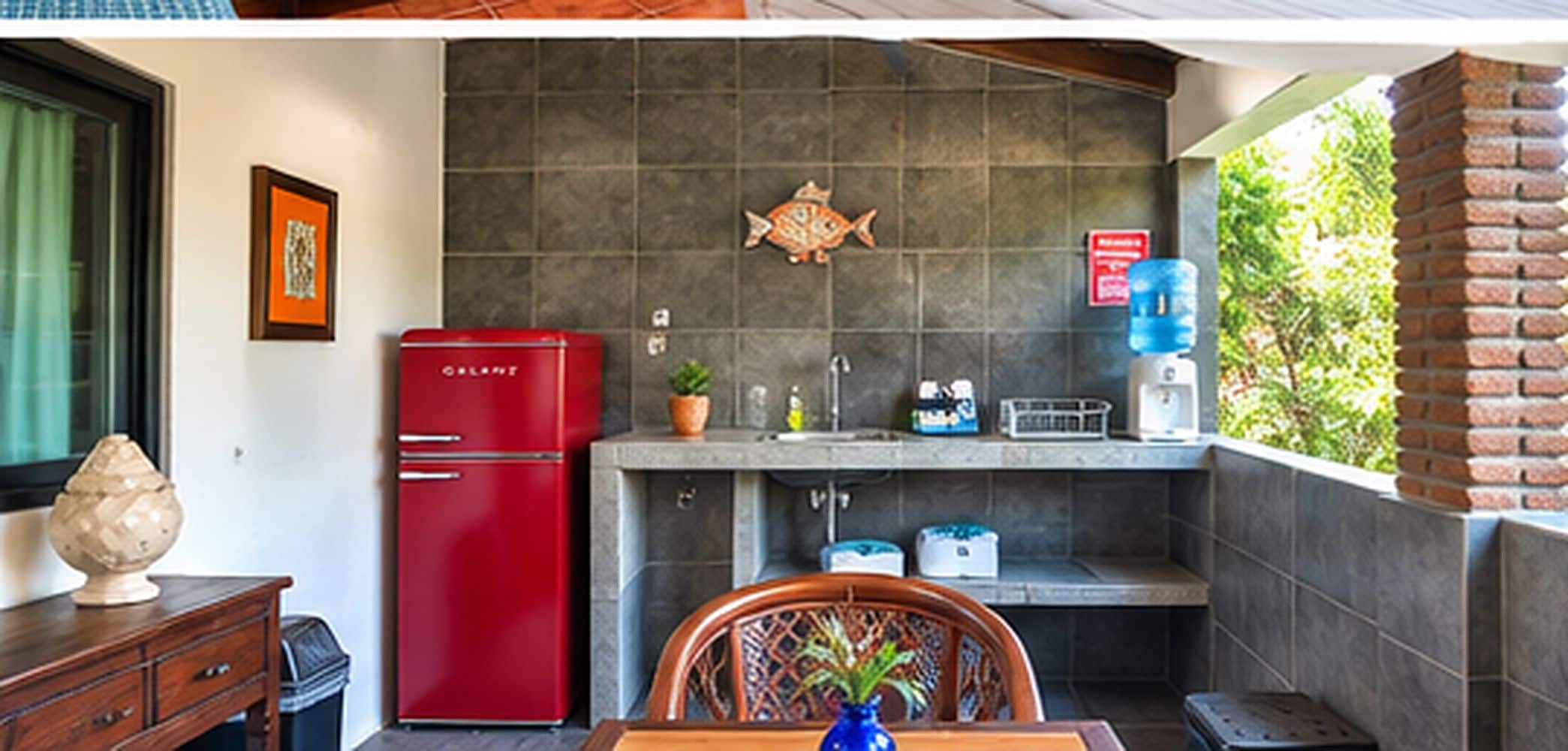 Una cocina compacta con un refrigerador rojo, un lavamanos y un dispensador de agua.