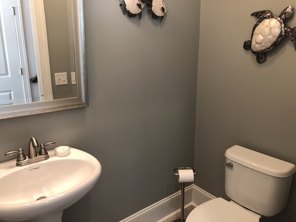 Un baño con lavabo, inodoro y espejo.